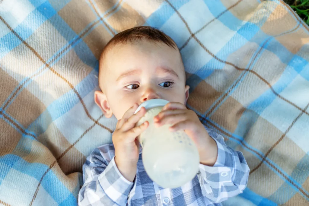 European Baby Formula vs American Baby Formula: Which is better? 4 adorable baby drinks milk from bottle while lying 2025 03 13 14 17 12 utc 1 1